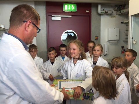 Der Leiter des Kinderlabors, Dr. Uwe Schwarzenbolz, zeichnet die 10-jährige Grundschülerin Josefine Bohn als 2.000 Teilnehmerin des Kinderlabors aus.